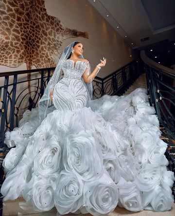 Superbe robe de mariée sirène à manches longues, décolleté en V et applications florales 3D, agrémentée de paillettes et de détails en cristal, traîne en dentelle amovible pour un look de mariée de rêve