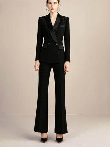 Elegante traje negro cruzado para mujer con detalles brillantes, pantalón de dos piezas con cuello sedoso y manga larga para un estilo chic otoñal.