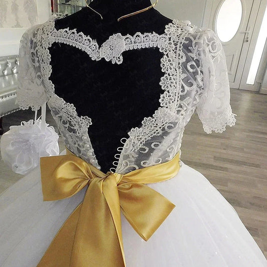 Elegante vestido de fiesta blanco con encaje bordado, corpiño de cuentas y mangas cortas para eventos formales.