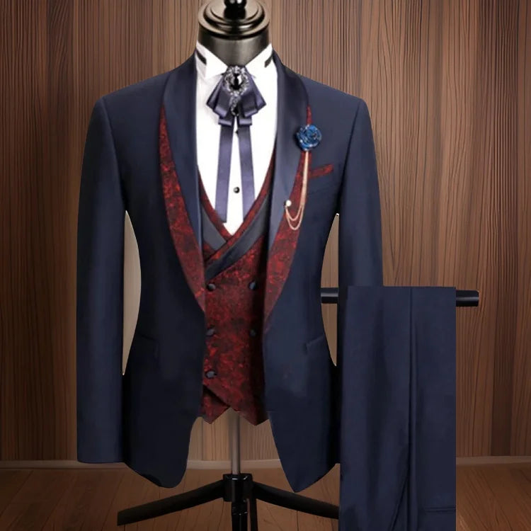 Traje azul marino de tres piezas para hombre con chaleco rojo de cachemira y elegantes accesorios.