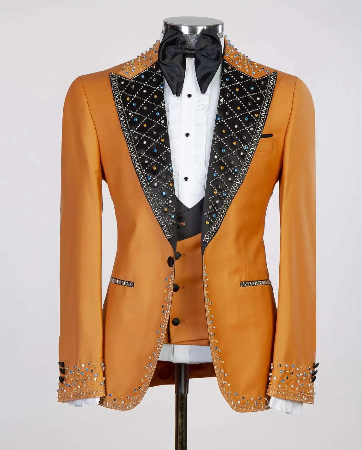 Blazer naranja para hombre con solapas negras, detalles tachonados y pajarita