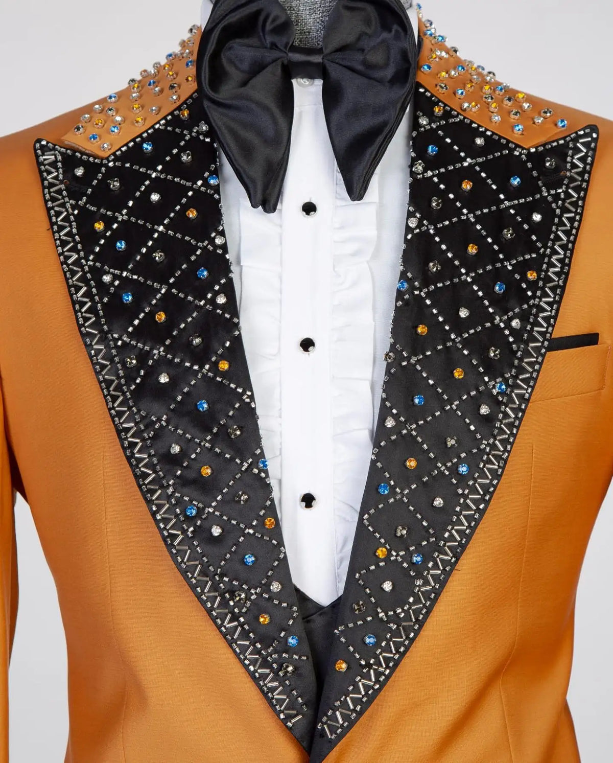 Blazer naranja para hombre con solapas negras, detalles tachonados y pajarita
