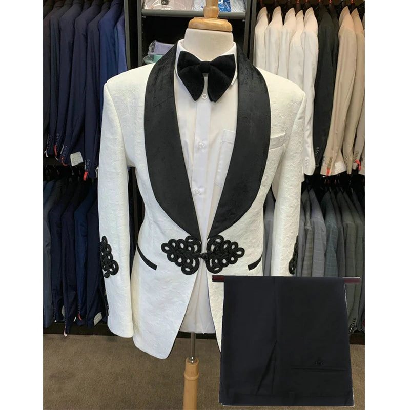 Veste blanche pour homme avec revers châle noir et détails brodés. Pantalon assorti inclus. 