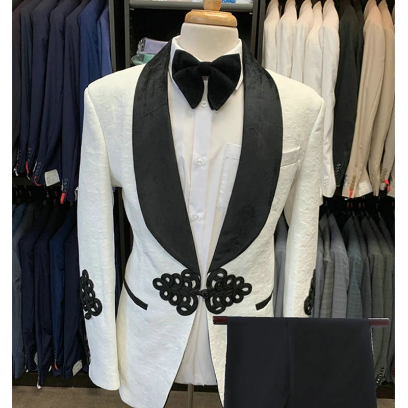 Veste blanche pour homme avec revers châle noir et détails brodés. Pantalon assorti inclus. 